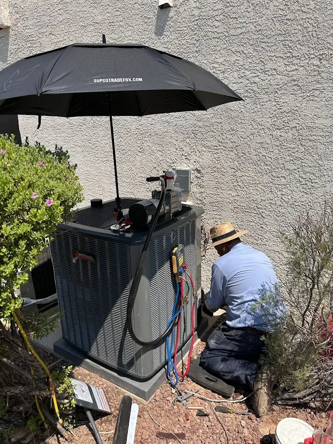 HVAC technician performing outdoor AC maintenance in Lyons